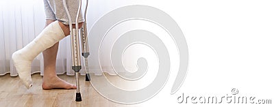 Close-up of man leg in plaster cast using crutches while walking Stock Photo