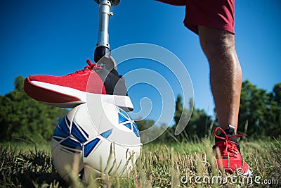 Close-up of man with mechanical leg playing football Stock Photo