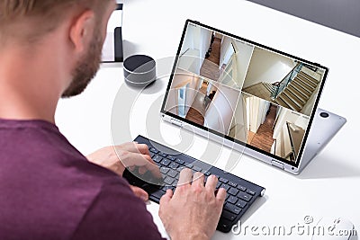 Businessman checking CCTV camera footage on laptop Stock Photo