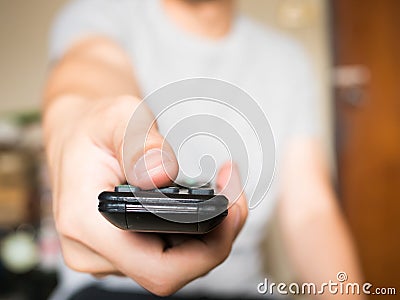 Close up of man pressing a button on remote control (shallow depth of field and focus on thumb) Stock Photo