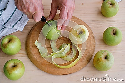 Close-up of man`s hands cutting golden apples Stock Photo