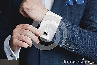 Close-up of a man in a tux fixing his cufflink. Stock Photo