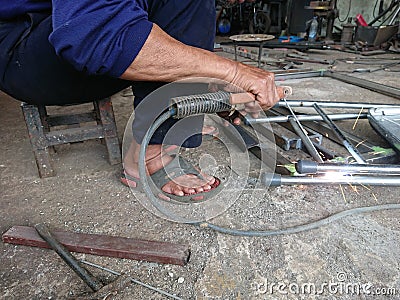close up, man welding broken chair at his workshop Stock Photo