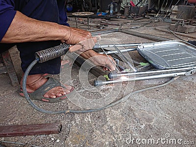 close up, man welding broken chair at his workshop Stock Photo