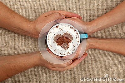 Man and woman hands hold full latte coffee cup Stock Photo