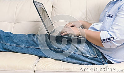 Close up of man working with laptop computer and sitting on sofa Stock Photo