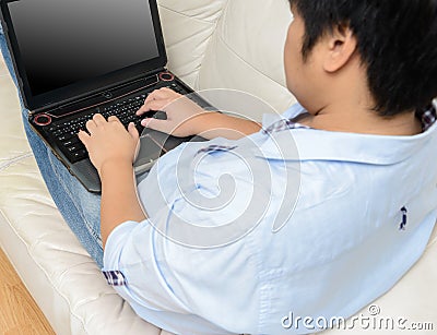 Close up of man working with laptop computer and sitting on sofa Stock Photo