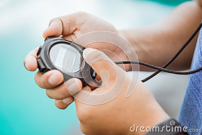 close up of a man& x27;s hand holding and setting a stopwatch Stock Photo