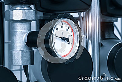 Close up of manometer, pipe, flow meter, water pumps and valves of heating system in a boiler room Stock Photo