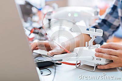 Close up of mans hands using laptop and remote controller Stock Photo