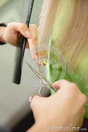 Close-up of master hairdresser shears with scissors dry ends of woman hair in salon Stock Photo