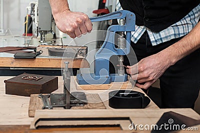 Close up, master work with press machine, tool and leather fittings Stock Photo
