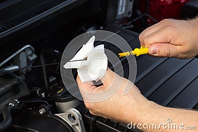 Close-up, the mechanic checks the oil level in the car Stock Photo