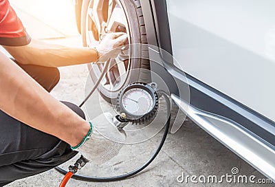 Close up mechanic inflating tire and checking air pressure with gauge pressure Stock Photo