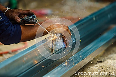 Close up the mechanic welding worker without safety in heavy industry. Danger and unsafety concept Stock Photo