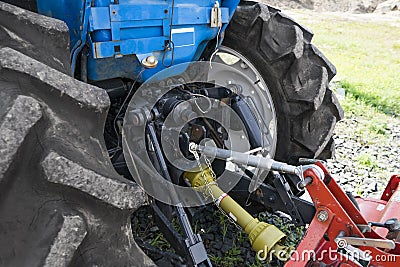 Close up on a mechanism of connection between small mini blue tractor and trailer. Stock Photo