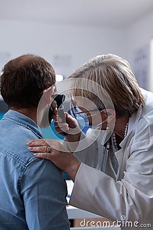 Close up of medic holding otoscope for ear examination with patient Stock Photo