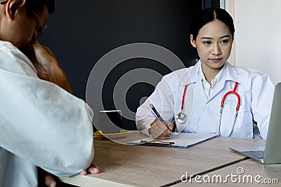 Close up medical doctor in white uniform gown coat interview and filling up an application form while consulting patient, medical Stock Photo