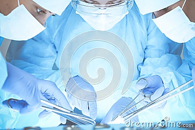 Close-up of medical team performing operation. Group of surgeons at work are busy of patient. Medicine, veterinary or Stock Photo