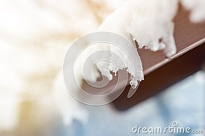 Close-up of melting snow icicles on roof. Falling water drops. Beginning of spring. Meeting cold and heat concept. Fresh spring na Stock Photo