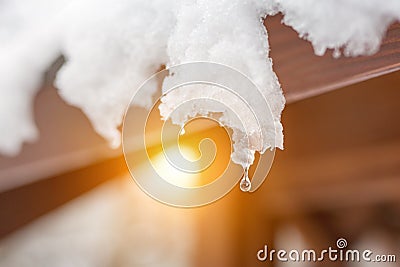Close-up of melting snow icicles on roof. Falling water drops. Beginning of spring. Meeting cold and heat concept. Fresh spring na Stock Photo