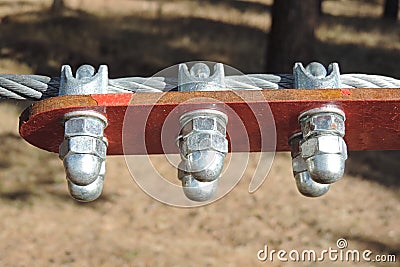 Close-up of metal ropes held together by clamps and bolts, steel wire rope and metal clamp are part of structure of rope park Stock Photo