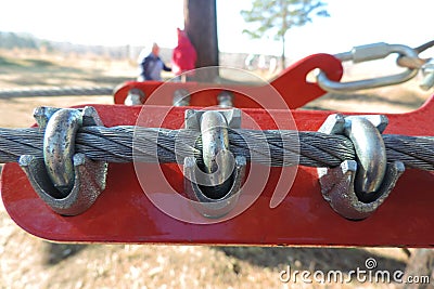 Close-up of metal ropes held together by clamps and bolts, steel wire rope and metal clamp are part of structure of rope park Stock Photo