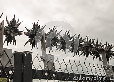 Close up of metal spikes on fence protecting power grid Stock Photo