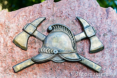 Close up of metal symbol of firefighters on a stone slab Stock Photo