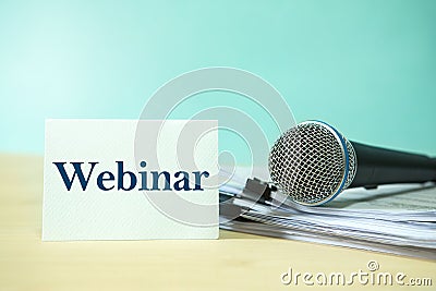 Close up Microphone on a paper document with Webinar text, concept of speaker or teacher preparation to speak in seminar class Stock Photo