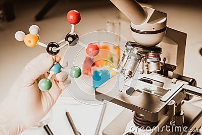 Close up of microscope viewing sample with atom ball and stick molecular model for research, learn. Stock Photo