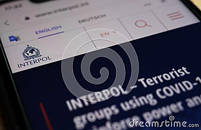 Close up of mobile phone with website of interpol with warning about covid-19 terrorists Editorial Stock Photo