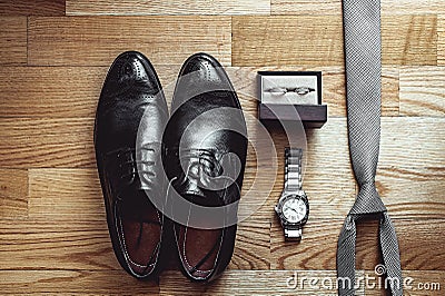 Close up of modern groom accessories. wedding rings, gray necktie, leather shoes and watch Stock Photo