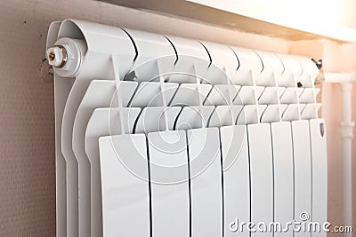 Close-up of modern home heating radiator under the window. Bimetal, aluminium radiator. Morning light Stock Photo