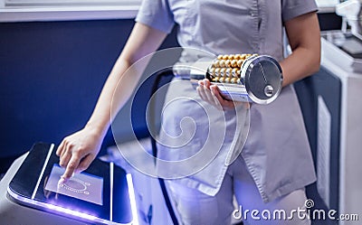 Close up of the monitor of the device for vacuum roller massage and cosmetologist hands Stock Photo