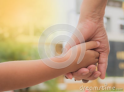 Close up of mother and a child hands at the sunset. Stock Photo