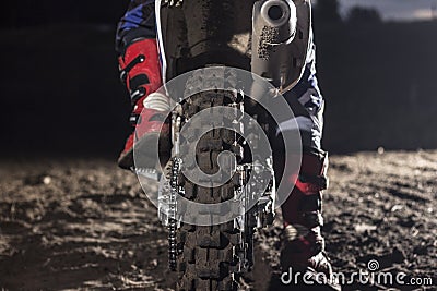 Close up of motocross wheel on the background of the track while driver sitting on the bike Stock Photo