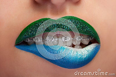 Close up mouth blue and green lips with glitter brackets Stock Photo