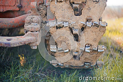 Close up muddy continuous caterpillar tracks of the bulldozer n a background of green grass Stock Photo