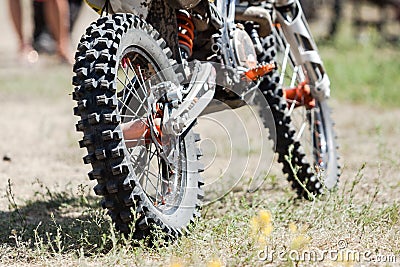 Close-up of muddy rear wheel and engine of dirt motorcycle Stock Photo