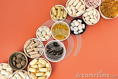 Close-up of multivitamin biologically active supplements on coral background. mental wellbeing and personal health concept Stock Photo