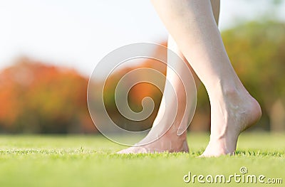 Woman`s barefeet walking on the grass. Stock Photo