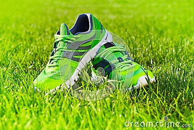 Close up new pairs of green running shoes / sneaker shoes on green grass field in the park Stock Photo