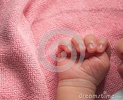 Close up newborn baby hand on pink blanket ,new family member sleeping with his mother look cutes. Stock Photo