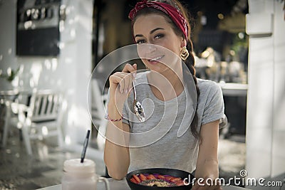 Close up of nice brunette with a plait has breakfast in outdoors cafe, Stock Photo