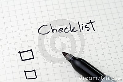 Close-up of notepad with pen and handwriting headline as Checklist with checkbox on table, to do list, prioritize or reminder for Stock Photo