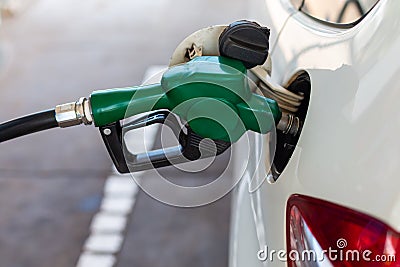close up nozzle fuel fill oil into car tank at pump gas station Stock Photo