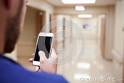 Close Up Of Nurse With Cellphone In Hospital Corridor Stock Photo