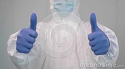 Close up of a nurse in a protective suit doing a thumbs up gesture. Covid 19 Stock Photo