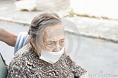 close-up of an octogenarian woman walking down the street in a wheelchair Stock Photo